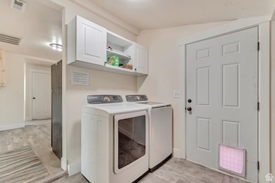 Laundry area featuring cabinet space and washing machine and clothes dryer