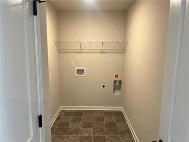 Laundry area with hookup for an electric dryer, hookup for a washing machine, and baseboards
