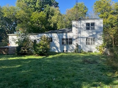 Back of property with a lawn