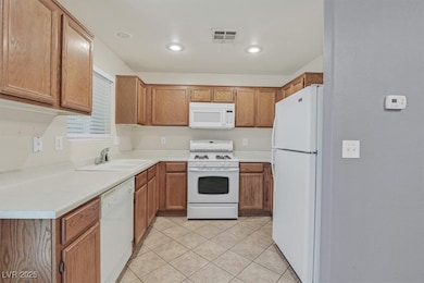 Kitchen featuring white appliances, brown cabinets