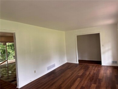Empty room featuring dark wood-style flooring and baseboards