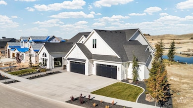 View of front of house with board and batten siding, driveway, and roof with shingles