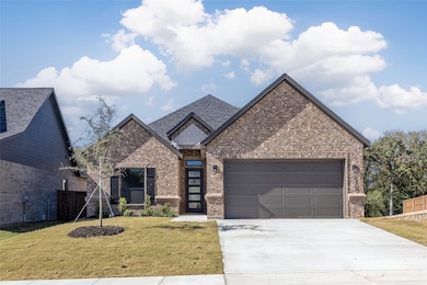 View of front of home featuring brick siding, concrete driveway, and an attached garage