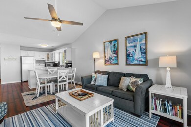 Living room featuring ceiling fan, dark hardwood /