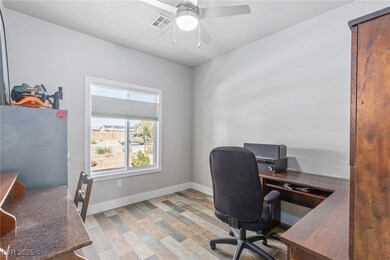 Office area with a ceiling fan and light wood-type