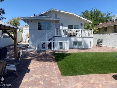 Rear view of house with stairs, a patio area, stuc
