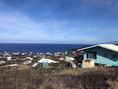 Looking west, driveway on right.  Curves down from street into lot.