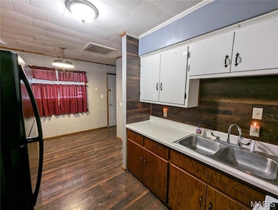 Kitchen featuring a sink, visible vents, light countertops, dark wood-style floors, and freestanding refrigerator
