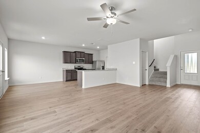 Unfurnished living room with light wood-style flooring, a ceiling fan, stairway, and recessed lighting