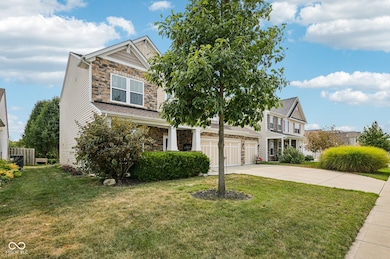 view of front of home featuring stone siding, driveway, a front yard, and a garage