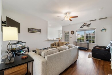 Living room featuring ceiling fan and dark hardwoo