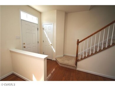 Foyer - Sunny foyer with hardwood floors, a coat c