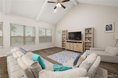 Living room featuring dark wood-type flooring, ceiling fan, high vaulted ceiling, and beamed ceiling