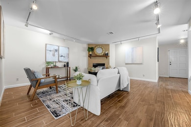 Living area with rail lighting, baseboards, and w