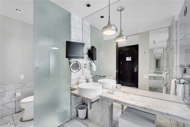 Bathroom featuring tile walls, visible vents, toil