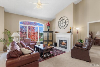 Living room featuring light carpet, a tile fireplace, high vaulted ceiling, and a ceiling fan