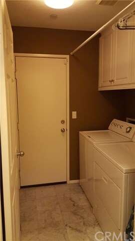 Downstairs laundry room with marble flooring and u