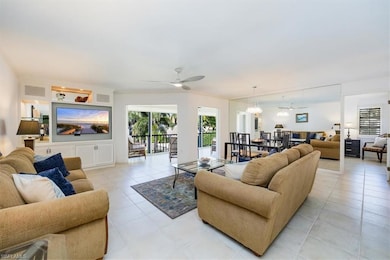 Living area with plenty of natural light, ceiling fan with notable chandelier, visible vents, and light tile patterned floors