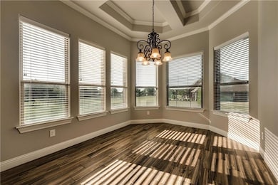 Unfurnished dining area with baseboards, dark wood-style floors, an inviting chandelier, and crown molding