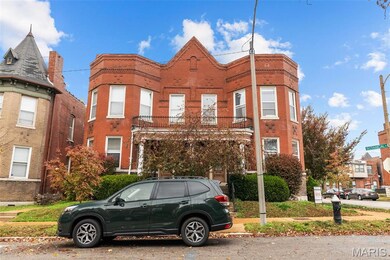 View of front of property featuring a balcony and brick siding