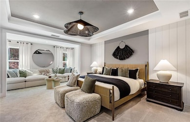 Carpeted bedroom featuring a tray ceiling and recessed lighting