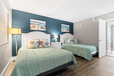 Bedroom with wood finished floors, baseboards, and lofted ceiling