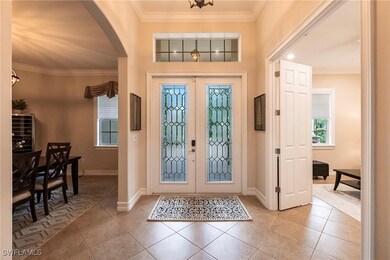 Foyer featuring arched walkways, french doors, lig