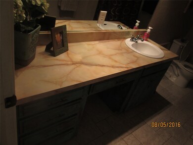 Bathroom featuring dark tile patterned floors and vanity