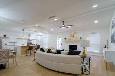 Living room with ceiling fan, sink, a brick firepl