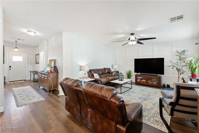 Living area featuring a ceiling fan and dark wood-