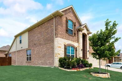 View of property exterior with stone siding, brick siding, a garage, and driveway