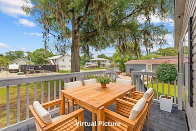 Wooden deck with outdoor dining area, a lawn, and a residential view