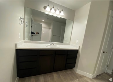 Full bathroom featuring vanity, dark wood finished floors, and a shower