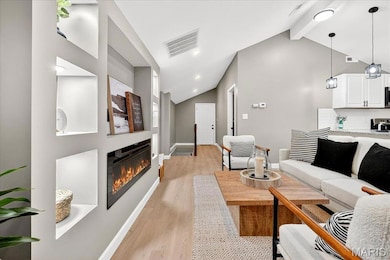 Living area featuring light wood-type flooring, an electric fireplace, and recessed lighting