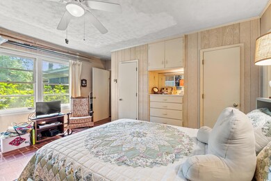 Bedroom with wood walls and a ceiling fan