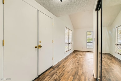 Foyer entrance featuring baseboards, a textured ce