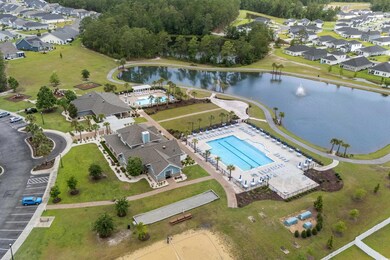 Aerial view of property's location featuring a pool and a nearby body of water