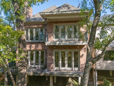 Two levels of balconies peer out to wooded views.