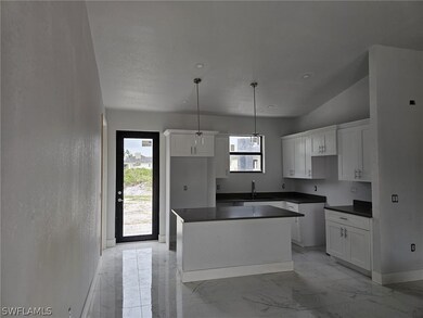 Kitchen featuring white cabinetry, a center island