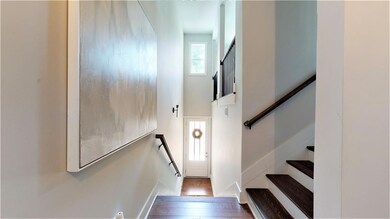 Stairs featuring wood finished floors and a high ceiling
