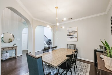 The formal dining room with crown molding, graceful arches and recently updated light fixture is to the right of the entryway as you step into the home.