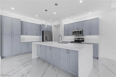 Kitchen featuring light marble finish floors, appl