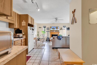 Kitchen with ceiling fan, white refrigerator, ligh
