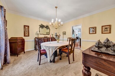 Dining area featuring a chandelier, ornamental molding, and light colored carpet