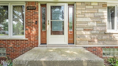 Charming front entry with a white glass-paneled door framed by brick and stone accents—adds character and warmth to the home's curb appeal