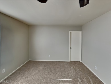 Carpeted spare room featuring baseboards