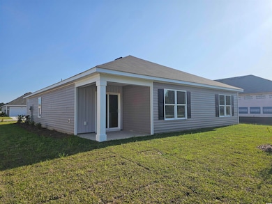 Rear view of property featuring a lawn and a patio
