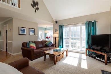 Spacious family room with vaulted ceiling and fireplace. Look at those windows that go all the way down to the floor, what amazing light!
