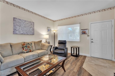 Living area with wood finished floors and baseboards