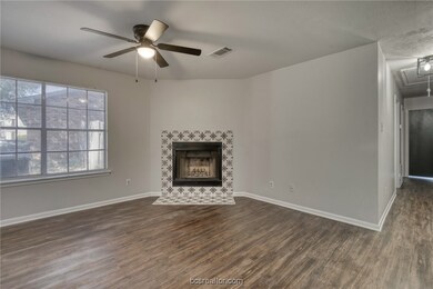Unfurnished living room featuring ceiling fan, dark hardwood / wood-style flooring, and a tile fireplace